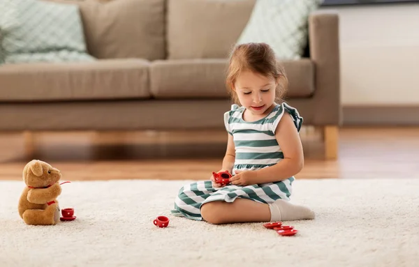 Little girl playing with toy tea set at home — Stock Photo, Image