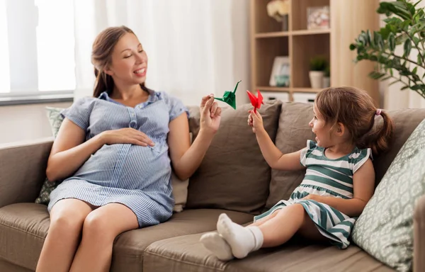 Pregnant mother and daughter with crane origami — Stock Photo, Image