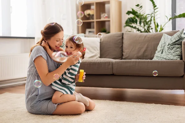 Schwangere Mutter und Tochter mit Seifenblasen — Stockfoto