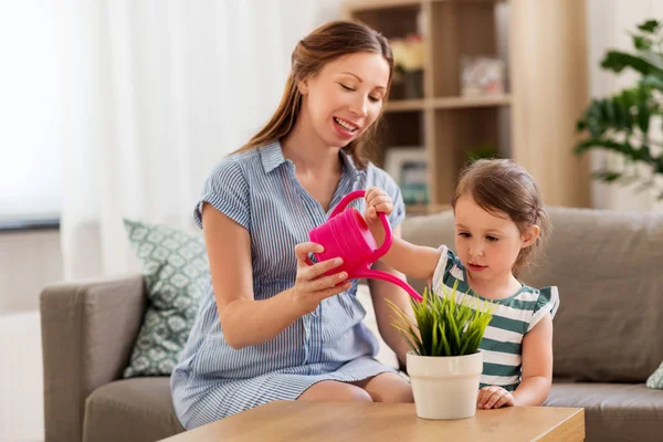 Zwangere moeder en dochter drenken huis plant — Stockfoto