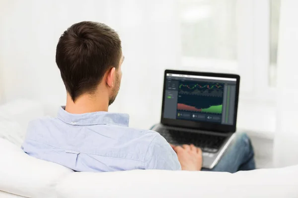 Man met grafieken op laptop scherm thuis — Stockfoto