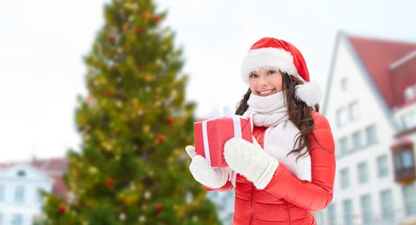 Happy woman with gift over christmas tree — Stock Photo, Image