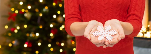 Närbild på kvinna som håller snöflinga på jul — Stockfoto