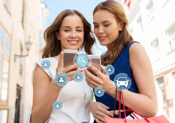 Women shopping and using car sharing on smartphone — Stock Photo, Image