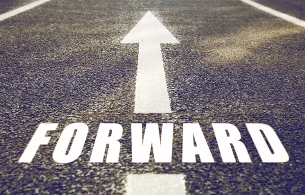 Close up of arrow and word forward on asphalt road — Stock Photo, Image