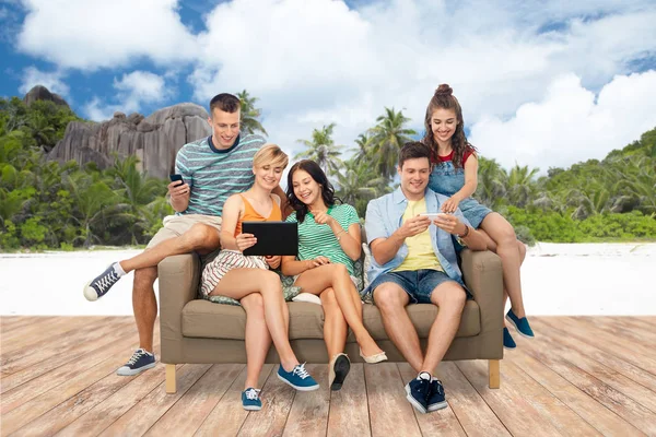 Freunde mit Tablet-PC und Smartphones am Strand — Stockfoto