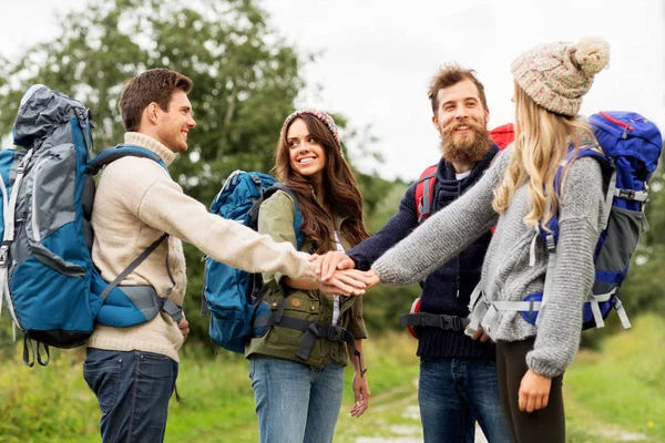 Friends with backpacks hiking and stacking hands — Stock Photo, Image