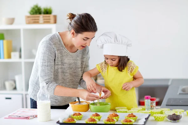 Gelukkig moeder en dochter bakken muffins thuis — Stockfoto