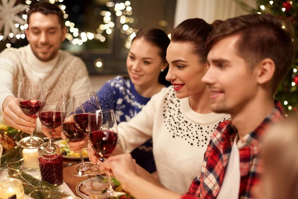 Amigos celebrando la Navidad y bebiendo vino —  Fotos de Stock