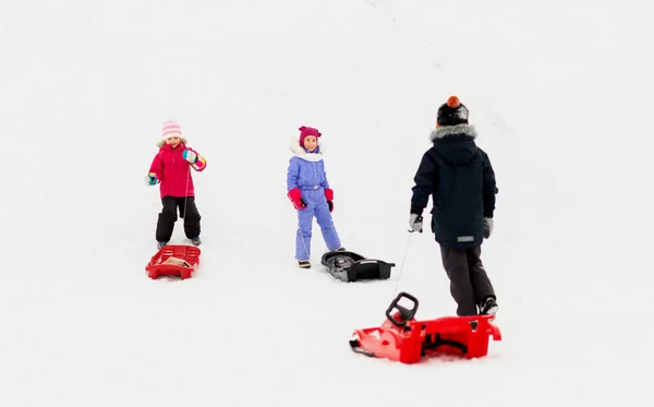 Crianças pequenas felizes com trenós no inverno — Fotografia de Stock