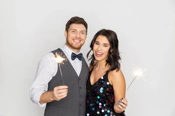 Casal feliz com sparklers na festa — Fotografia de Stock