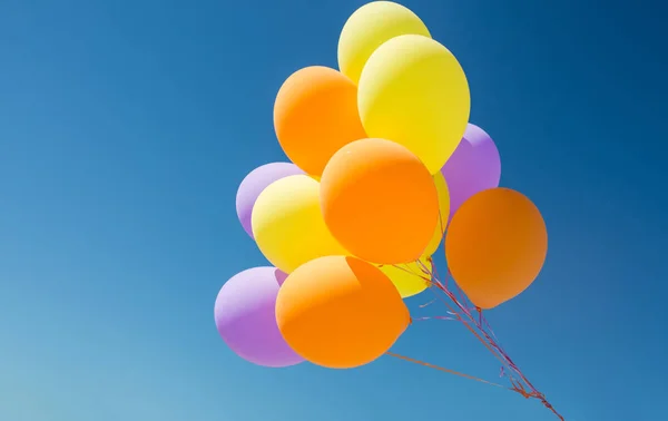 Primo piano di palloncini di elio colorati nel cielo blu — Foto Stock