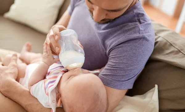Close up of father feeding baby from bottle — Stock Photo, Image