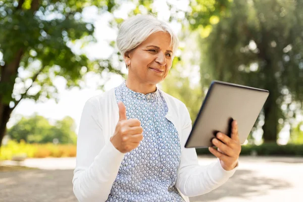 Äldre kvinna med TabletPC visar tummen — Stockfoto