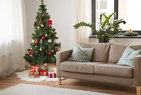 Árvore de natal, presentes e sofá em casa aconchegante — Fotografia de Stock
