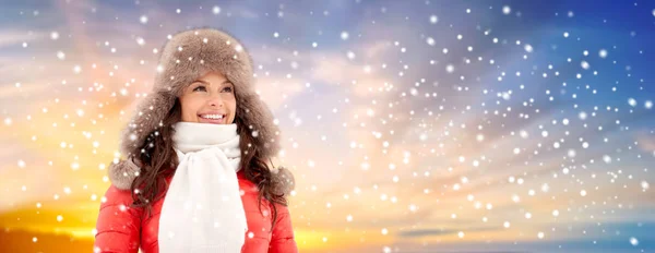 Happy woman in winter fur hat over sky and snow — Stock Photo, Image