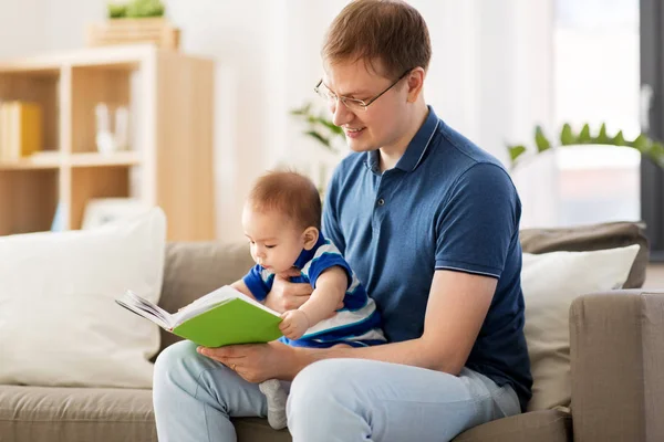 Gelukkig vader en zoontje van de baby met boek thuis — Stockfoto