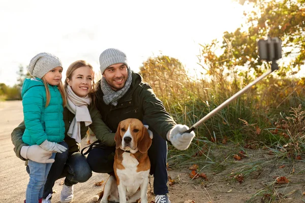 Famille heureuse avec chien prenant selfie en automne — Photo