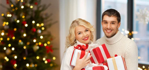 Glada par med julklappar hemma — Stockfoto