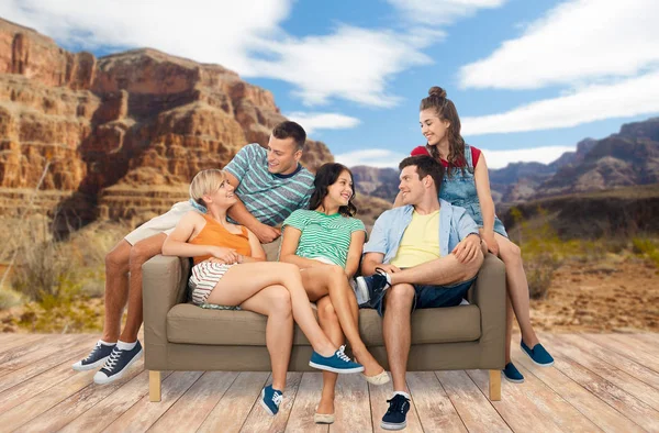 Friends sitting on sofa over grand canyon — Stock Photo, Image