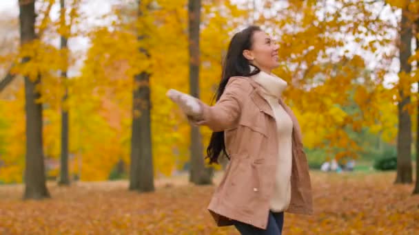 Счастливая молодая женщина в осеннем парке — стоковое видео