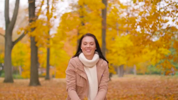 Mujer feliz divirtiéndose con hojas en el parque de otoño — Vídeos de Stock