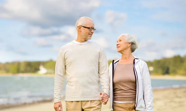 Happy senior couple over beach background — Stock Photo, Image