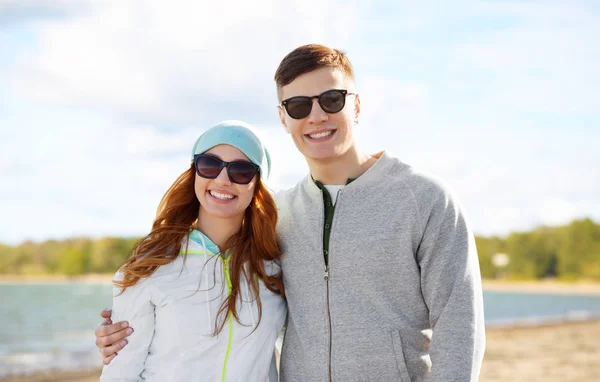 Boldog tinédzser pár felett strand háttér — Stock Fotó
