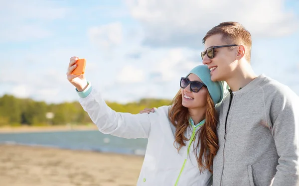 Šťastný dospívající pár pořizování selfie ve smartphone — Stock fotografie