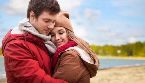 Feliz casal adolescente abraçando sobre praia de outono — Fotografia de Stock