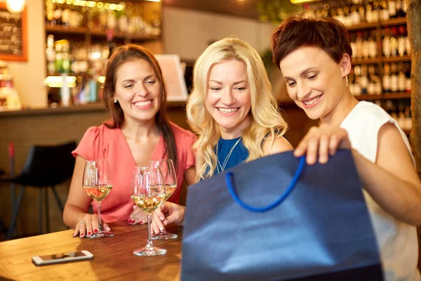 Mulheres com sacos de compras no bar ou restaurante de vinhos — Fotografia de Stock