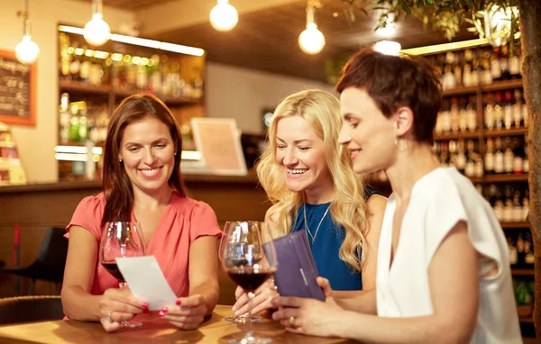 Mujeres mirando la factura en el bar de vinos o restaurante —  Fotos de Stock