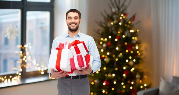 Glücklicher Mann mit Weihnachtsgeschenken zu Hause — Stockfoto