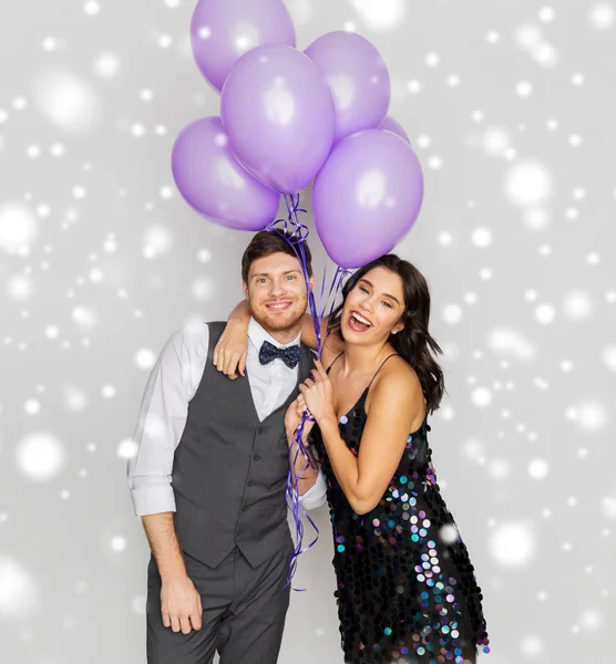 Glückliches Paar mit ultravioletten Luftballons auf Party — Stockfoto