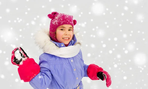 Chica feliz jugando y lanzando bola de nieve en invierno — Foto de Stock