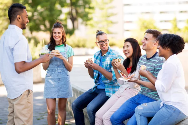 Vänner äta pizza och smörgåsar i park — Stockfoto