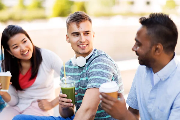 Vänner som dricker kaffe och juice talar i city — Stockfoto