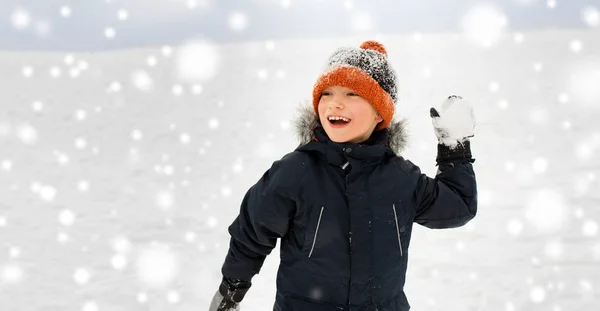 Szczęśliwy chłopiec gra i rzucanie Śnieżki zimą Obrazek Stockowy