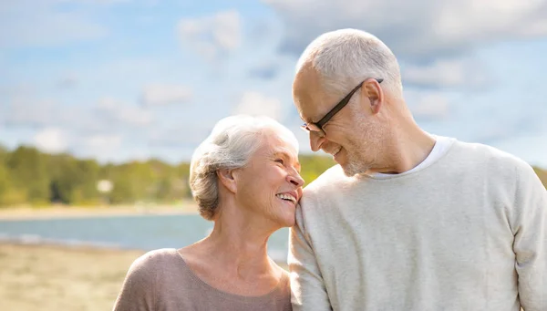 Happy senior couple over beach background — Stock Photo, Image