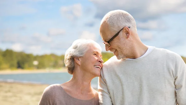 Feliz pareja de ancianos sobre fondo de playa — Foto de Stock