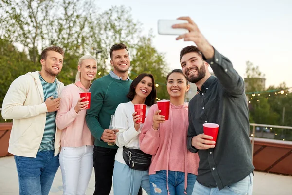 Amigos con bebidas tomando selfie en la fiesta en la azotea —  Fotos de Stock