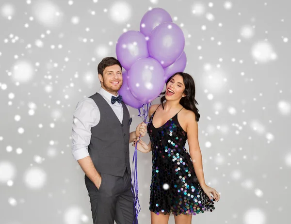 Feliz pareja con ultra violeta globos en la fiesta — Foto de Stock