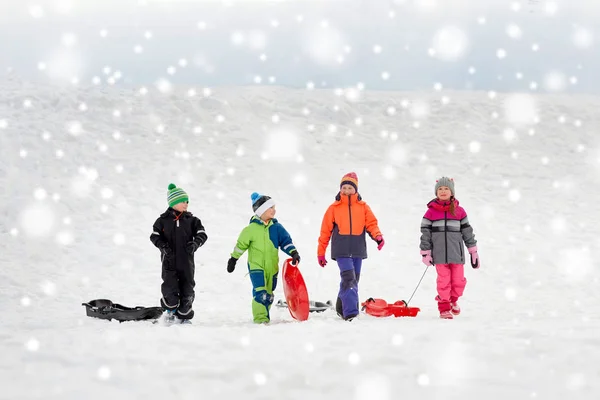 Mutlu küçük kışın sledging kızaklarımız ile çocukların — Stok fotoğraf