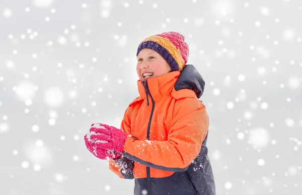 Glückliches Mädchen, das im Winter mit Schnee spielt — Stockfoto