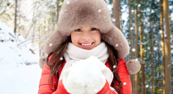 Kvinna i pälsmössa med snö över vintern skog — Stockfoto