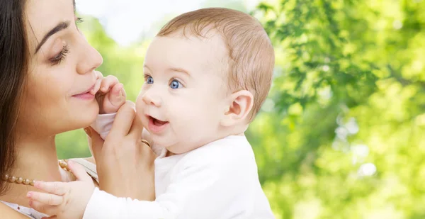 Mor med baby över grön naturliga bakgrund — Stockfoto