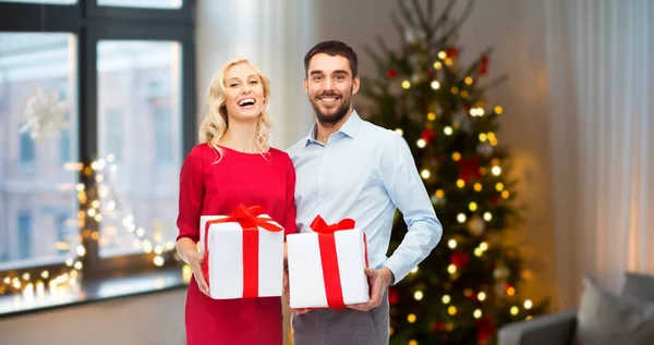 Pareja feliz con regalos de Navidad en casa —  Fotos de Stock