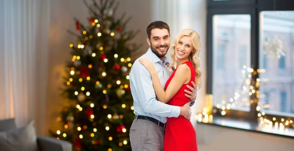 Feliz casal abraçando em casa no Natal — Fotografia de Stock