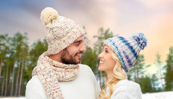 Feliz pareja en sombreros sobre invierno bosque fondo —  Fotos de Stock