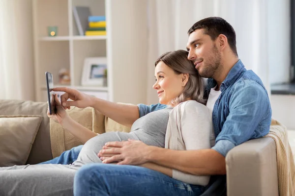 Беременность Технологии Концепция Людей Счастливый Мужчина Беременная Жена Планшетным Компьютером — стоковое фото